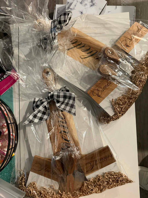 Gift ready personalized charcuterie board set with engraved name and matching cheese knives, wrapped with a ribbon